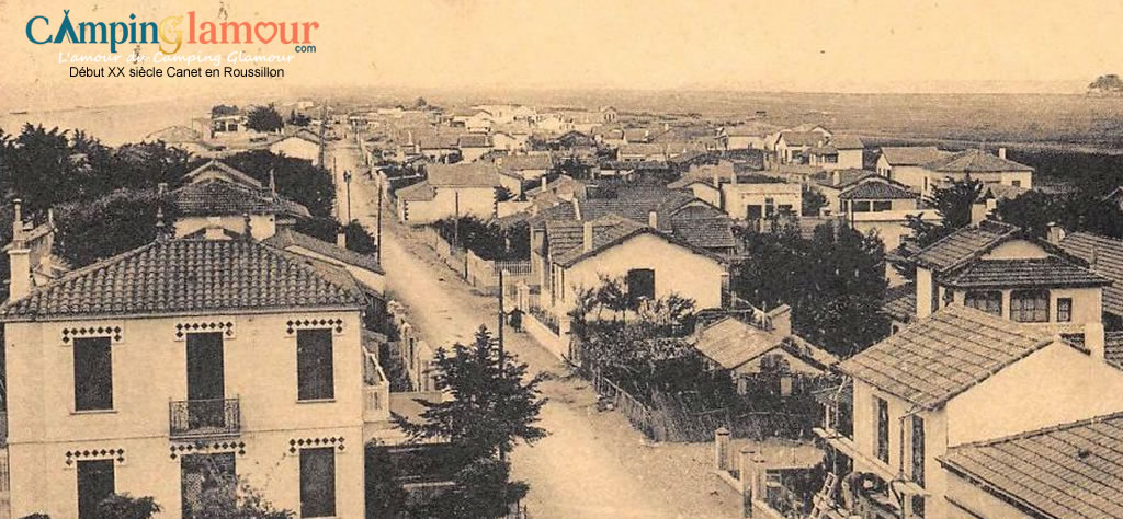 Image en noir et blanc de la plage de Canet au début du 20ème siècle, avec des baigneurs et des cabines de plage d'époque