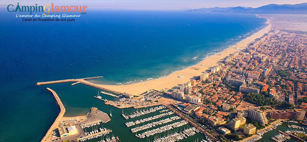Vue panoramique moderne de Canet-en-Roussillon, montrant la plage animée, le port de plaisance et les bâtiments récents